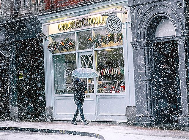 Marcher devant les cafés et les magasins à Noël alors qu'il neige
