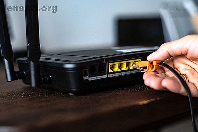 Utilisateur réinsérant le câble dans un routeur Wi-Fi